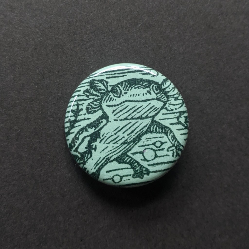 baby salamander stamped on a button